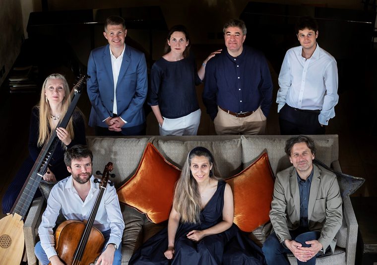 A group of performers sitting with their instruments