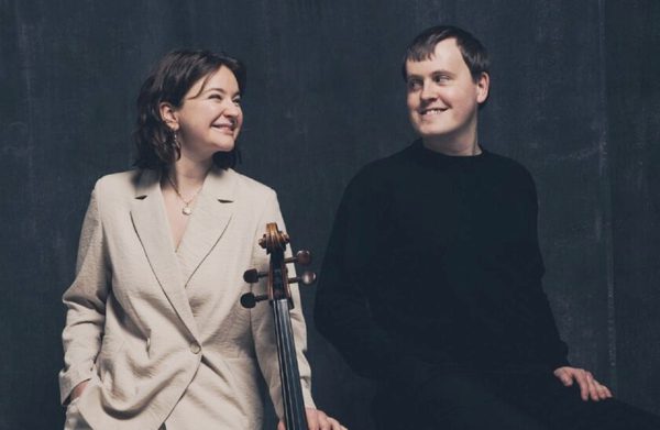 Performers looking at each other and holding an instrument