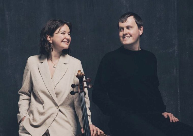 Performers looking at each other and holding an instrument