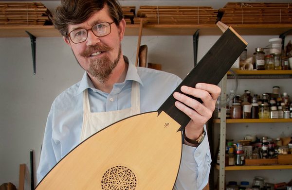 The performer facing the camera holding an instrument