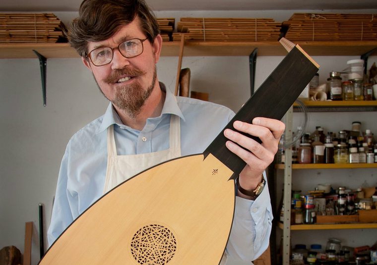 The performer facing the camera holding an instrument