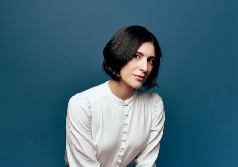 The performer against a blue background