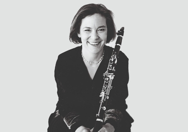 The performer looking at the camera and holding their instrument