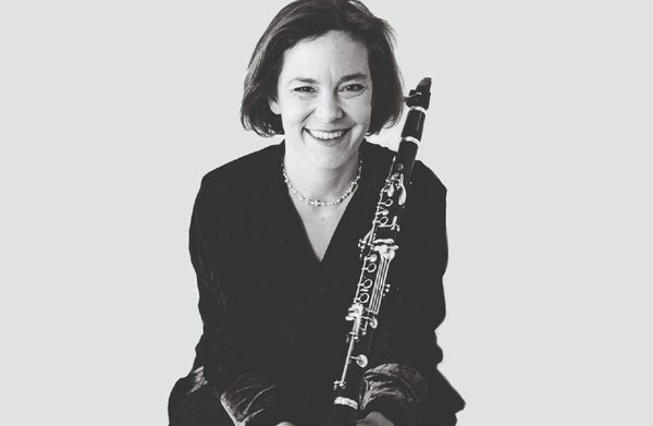 The performer looking at the camera and holding their instrument