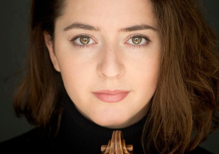 The performer against a black background looking at the camera