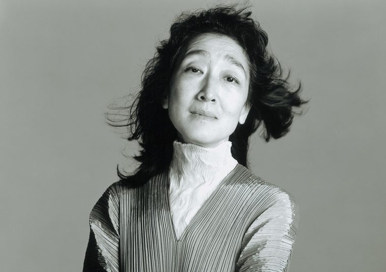 Performer standing against a gray background