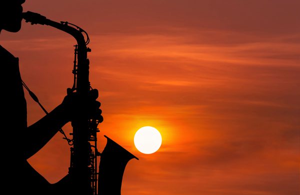 An instrument being played against a setting sun