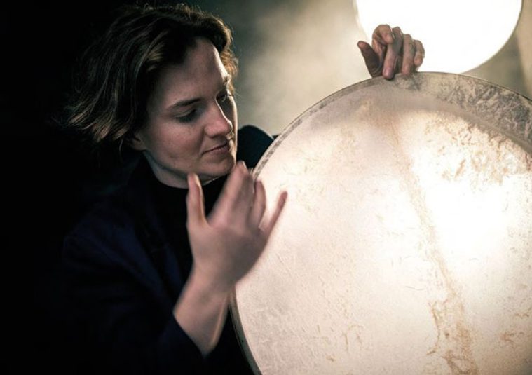 A performer holding a percussion instrument