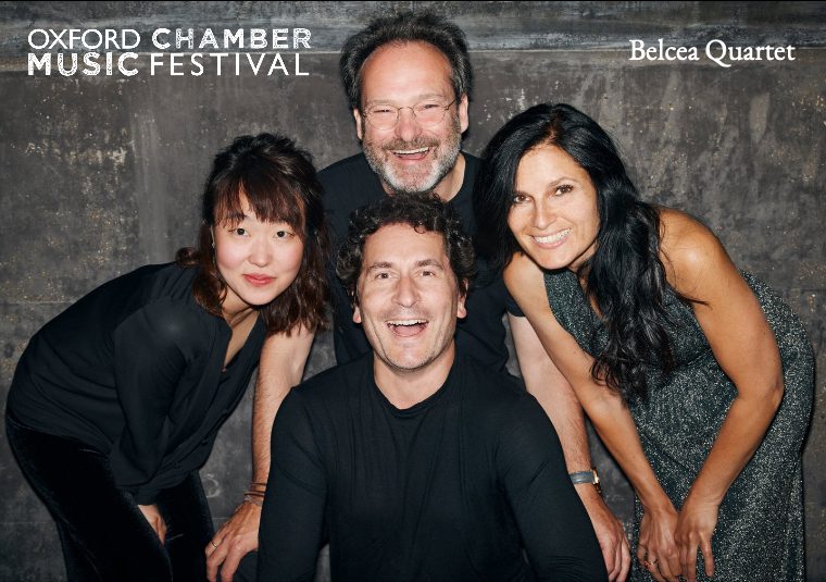 The performers against a gray background looking at the camera