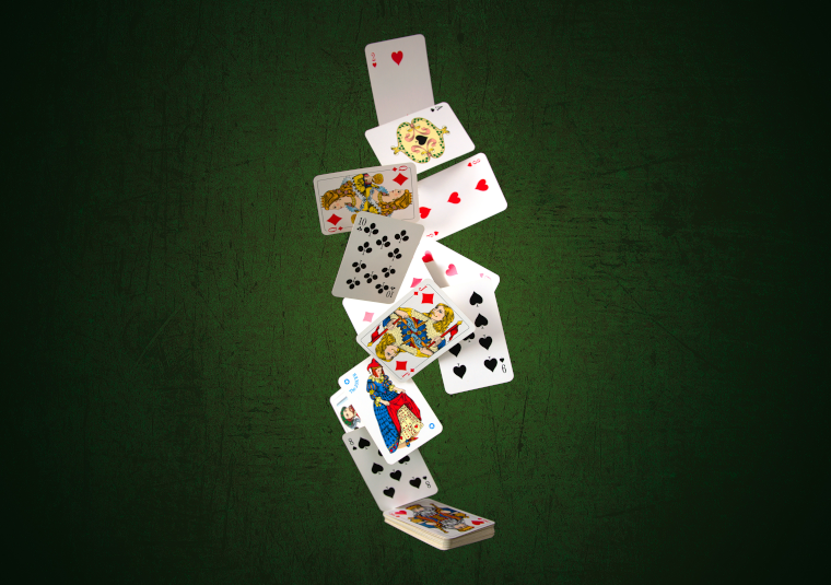 A selection of playing cards tumbling onto a green playing table
