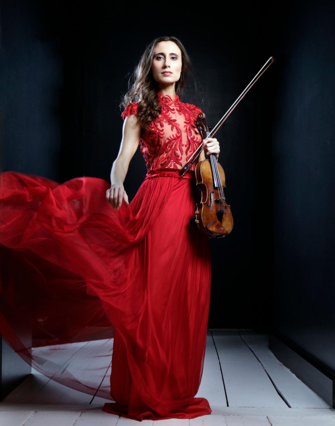 Performer holding instrument and wearing a red dress