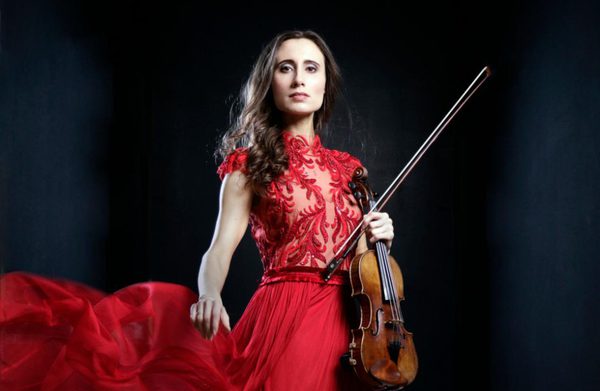 Performer holding instrument and wearing a red dress