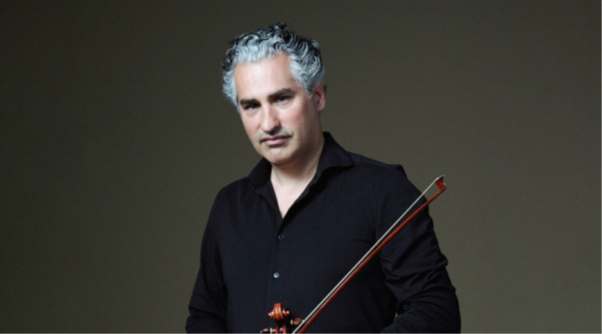 Performer against a gray background looking at camera