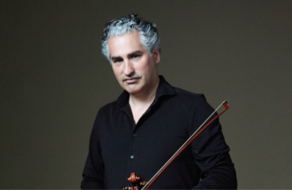 Performer against a gray background looking at camera