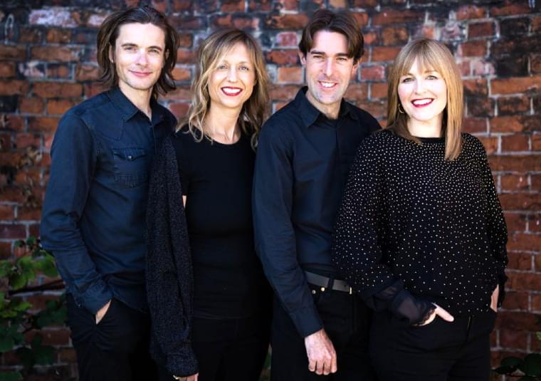 The performers standing against a wall made of bricks