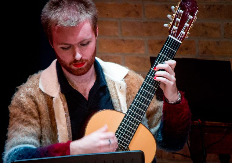 Performer holding guitar