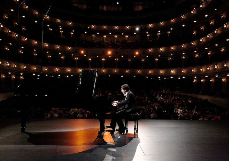 The performer playing an instrument in a concert hall
