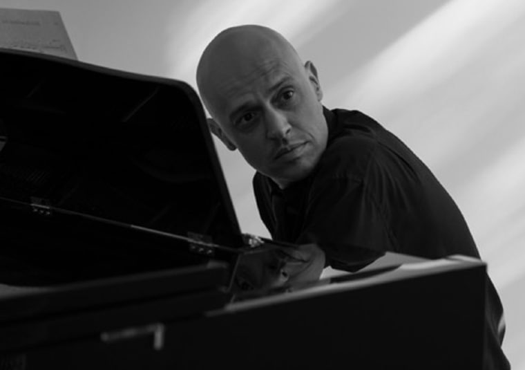 The performer sitting at a piano