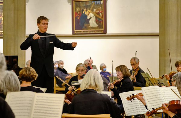 A conductor conducting an orchestra in a venue
