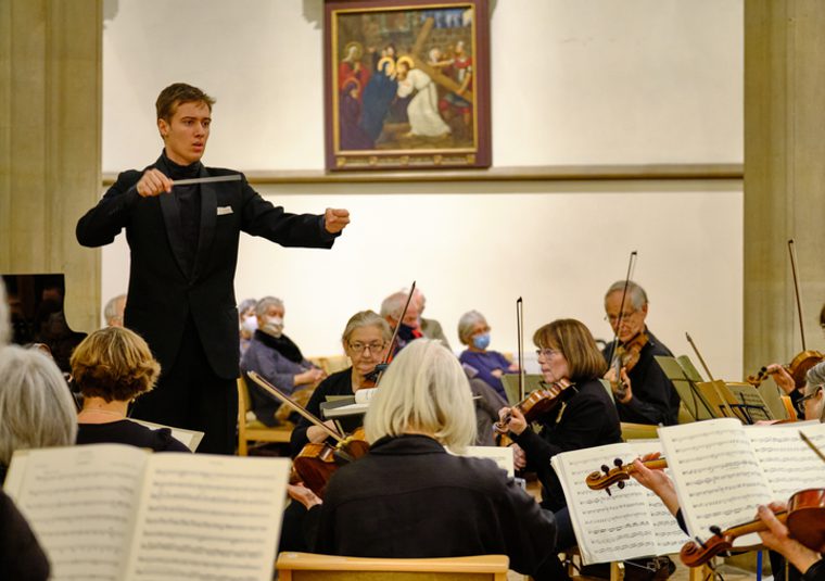 A conductor conducting an orchestra in a venue