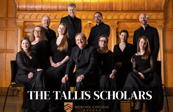 Performers gathered inside a venue looking at camera