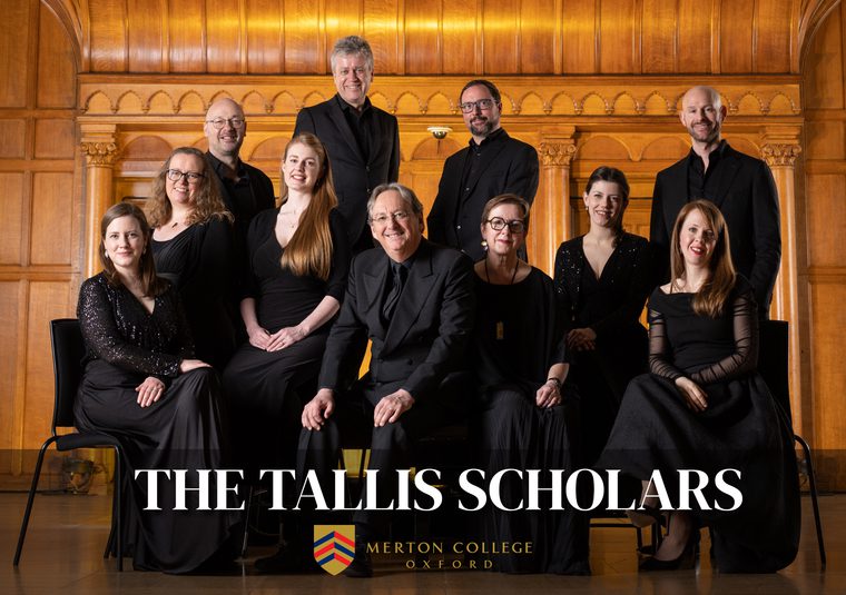 Performers gathered inside a venue looking at camera